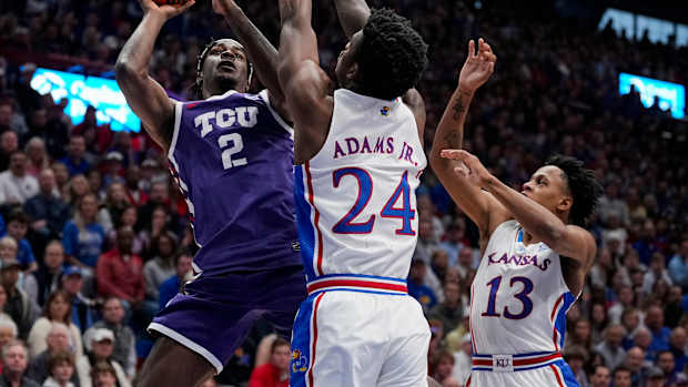 Jan 6, 2024; Lawrence, Kansas, USA; TCU Horned Frogs forward Emanuel Miller (2) shoots against Kansas Jayhawks forward K.J. Adams Jr. (24) and guard Elmarko Jackson (13) during the first half at Allen Fieldhouse. Mandatory Credit: Jay Biggerstaff-USA TODAY Sports
